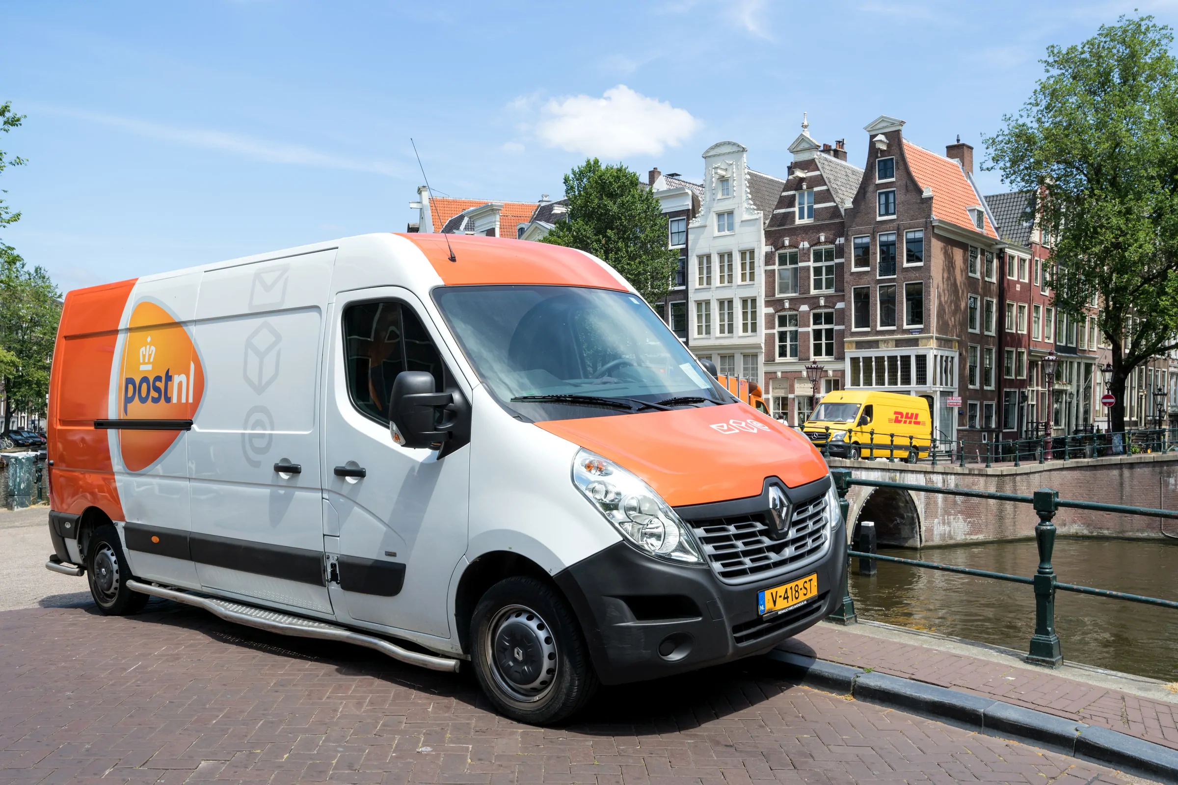 Bezorgbus langs een gracht in een Nederlandse binnenstad