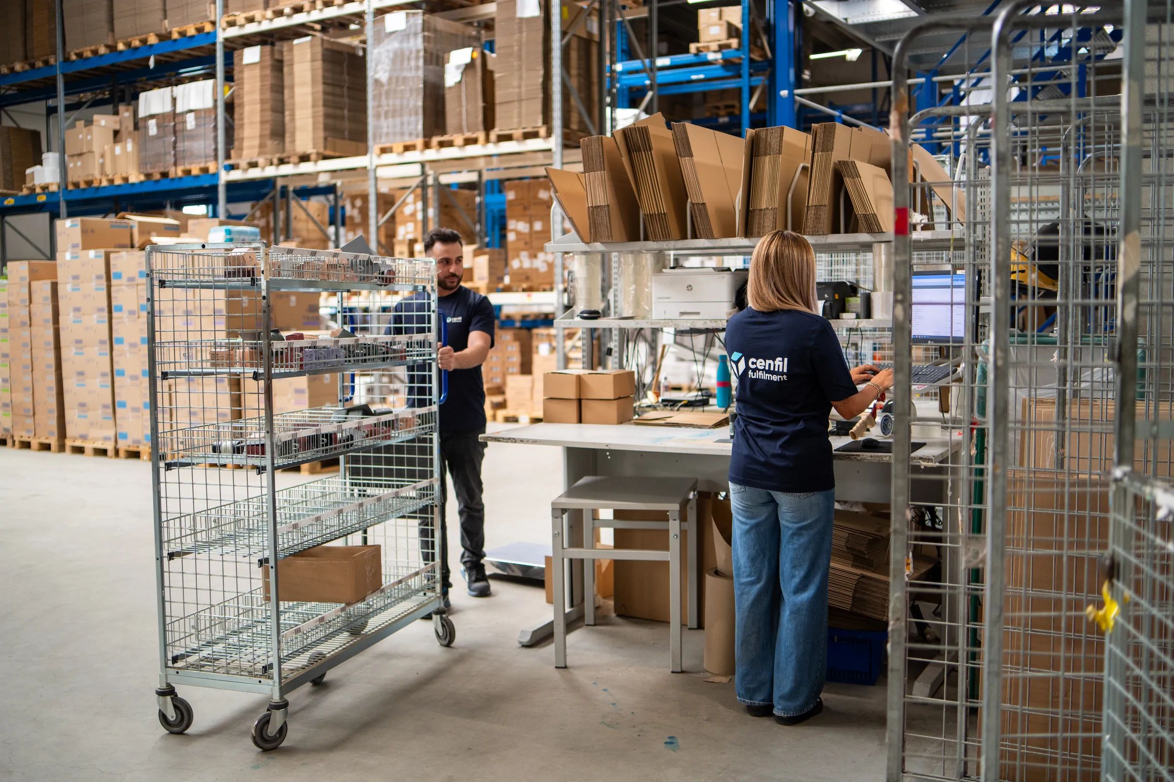 Zwei Mitarbeiter arbeiten gemeinsam am Verpackungstisch
