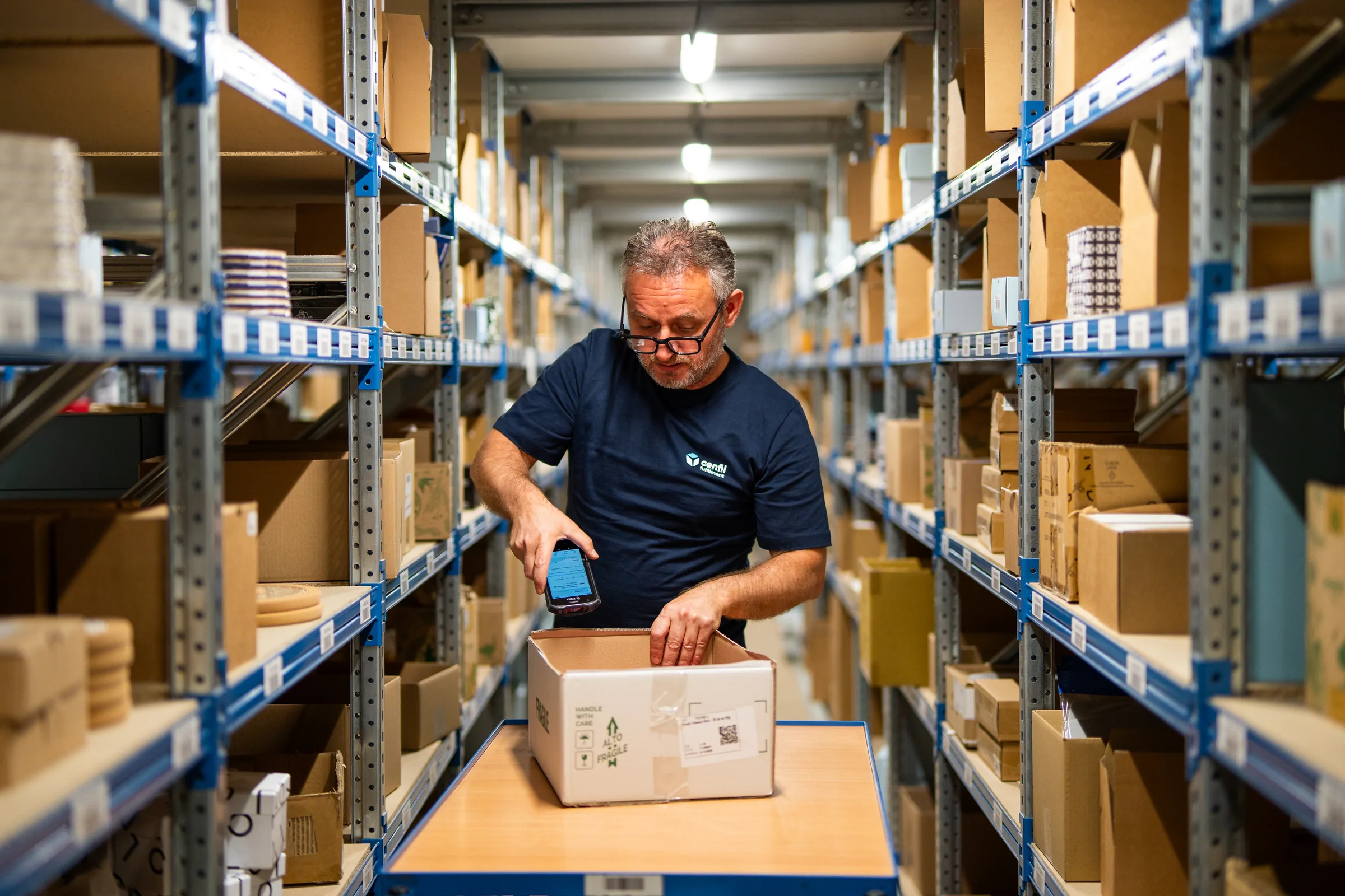 Ein Mitarbeiter entnimmt ein Produkt aus dem Regal im Cenfil-Fulfillment-Center in Drunen