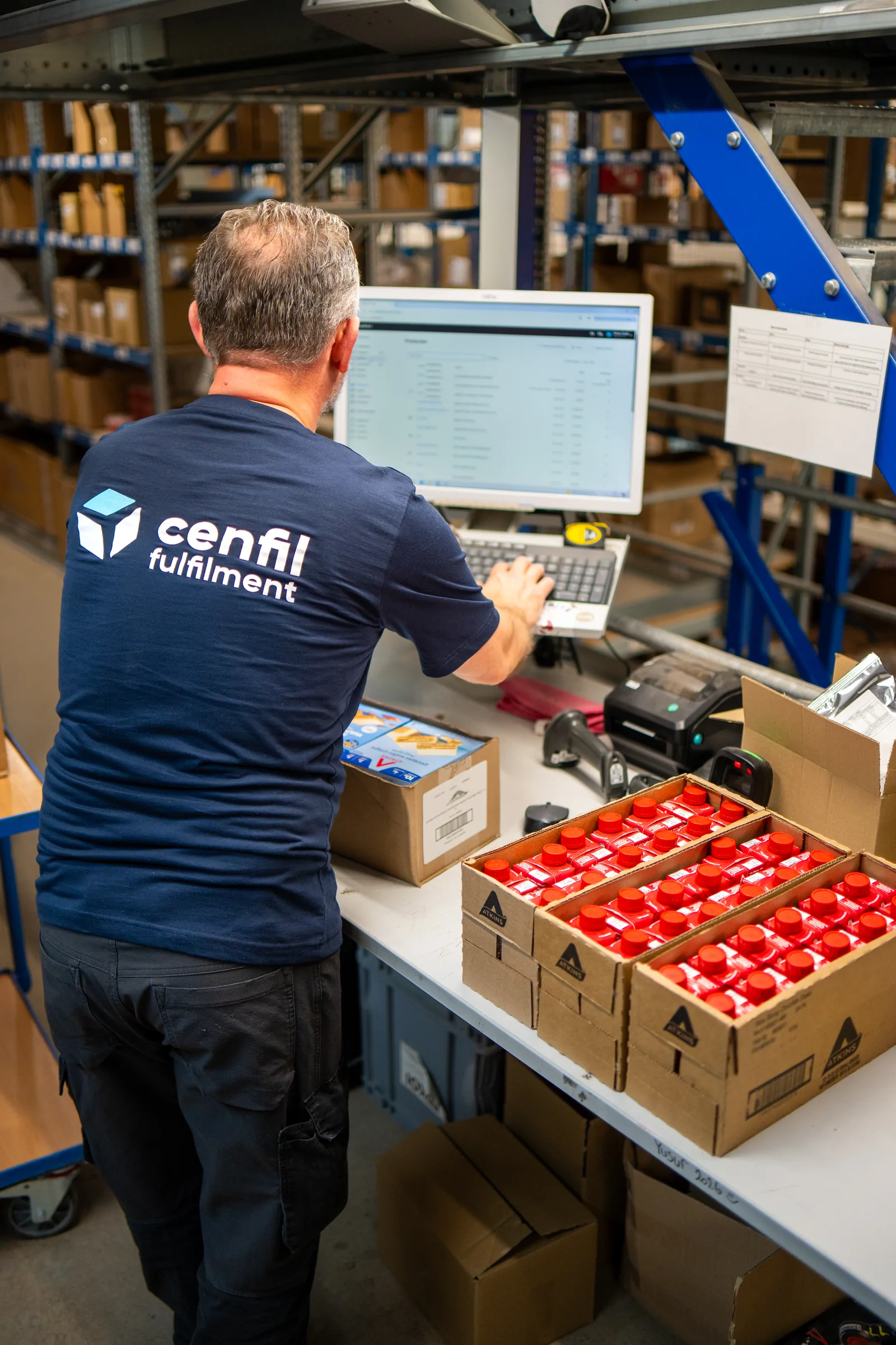 Medewerker verpakt flessen aan de inpaktafel