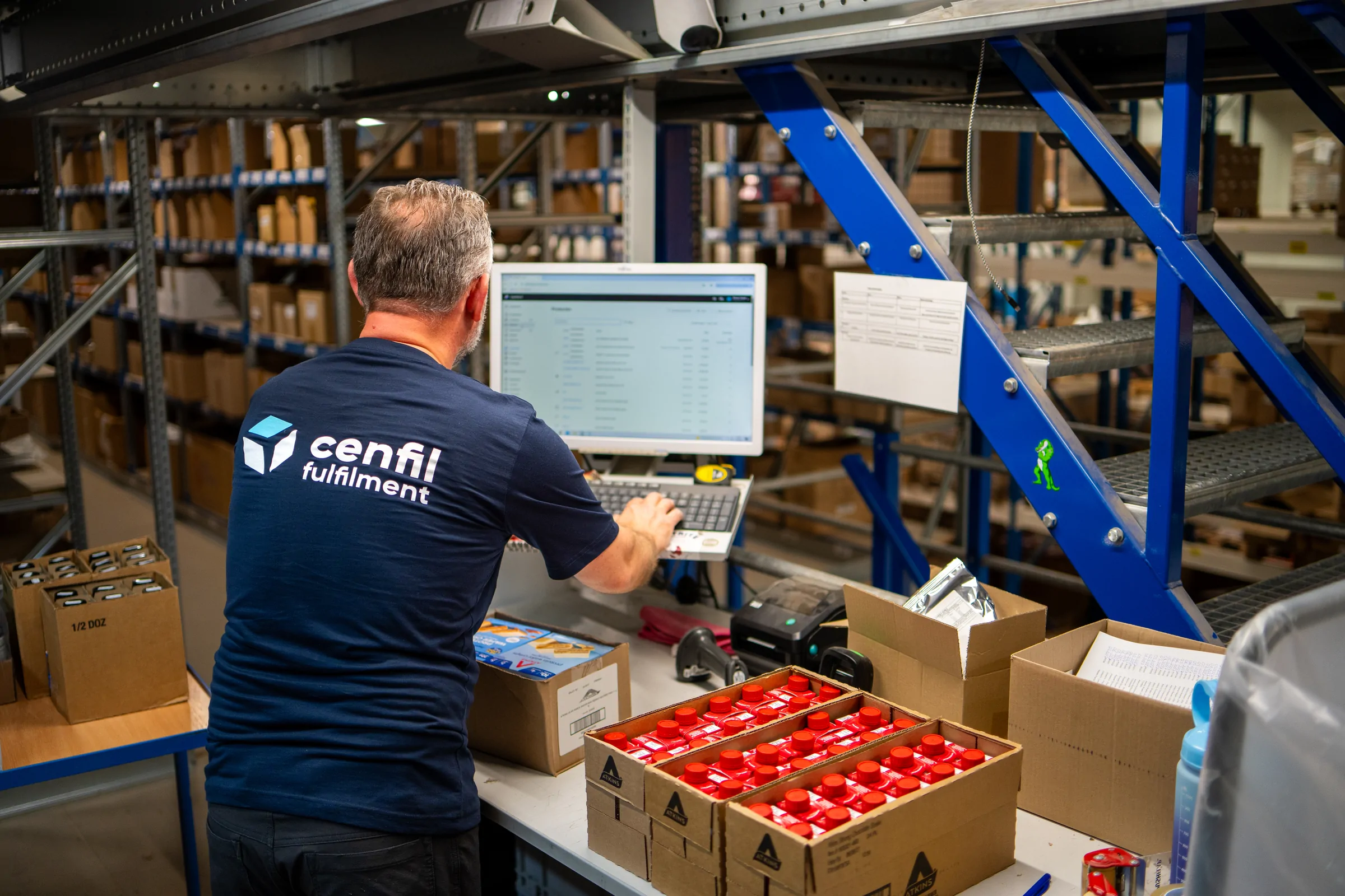 Medewerker werkt aan een scherm bij de inpaktafel